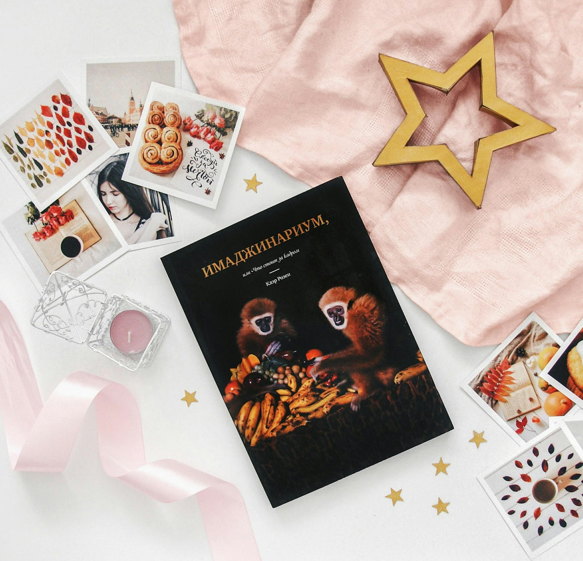 Book with monkeys, photos, and star decoration on pink fabric.